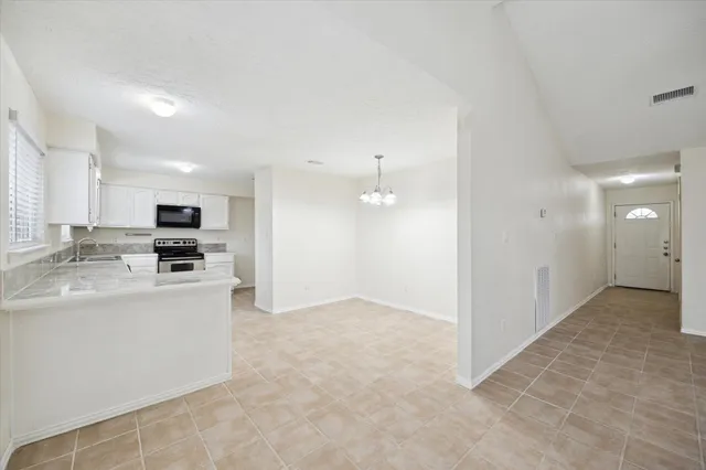a view of kitchen with kitchen island stainless steel appliances refrigerator sink and cabinets