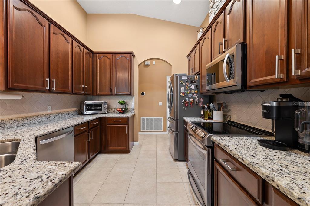 9020 North River Road Tampa, FL 33635 - Photo 19 of 86 a kitchen with stainless steel appliances granite countertop a stove a sink and a microwave