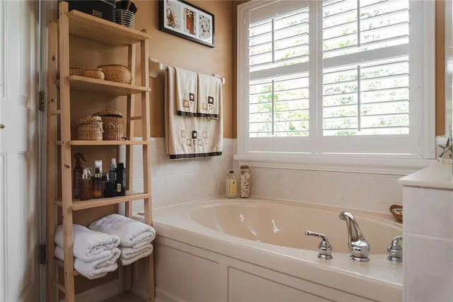 a view of an empty room with wooden floor and a ceiling fan