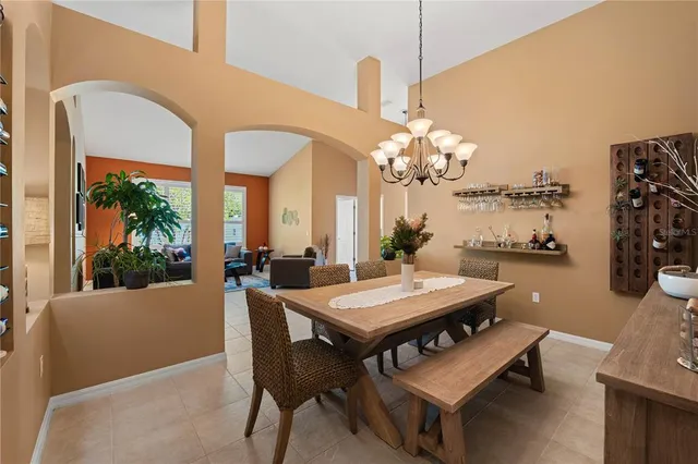 a kitchen with granite countertop a refrigerator a stove top oven a dining table and chairs