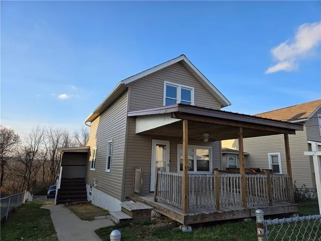 a view of house with a yard and deck