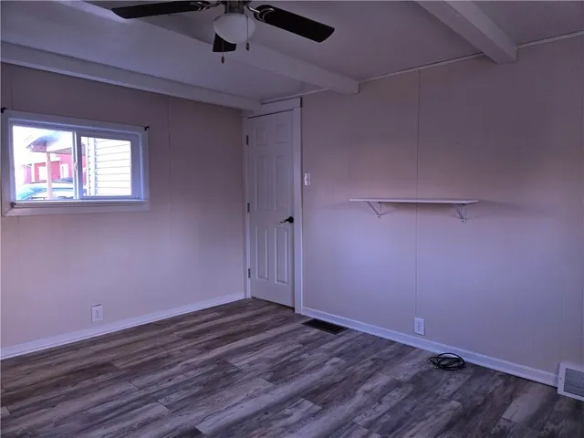 a view of room with hardwood floor and a ceiling fan