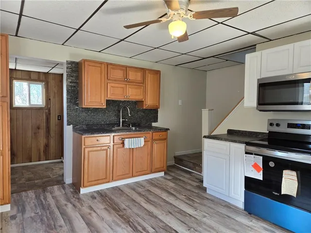 a kitchen with stainless steel appliances granite countertop a stove a sink and a microwave