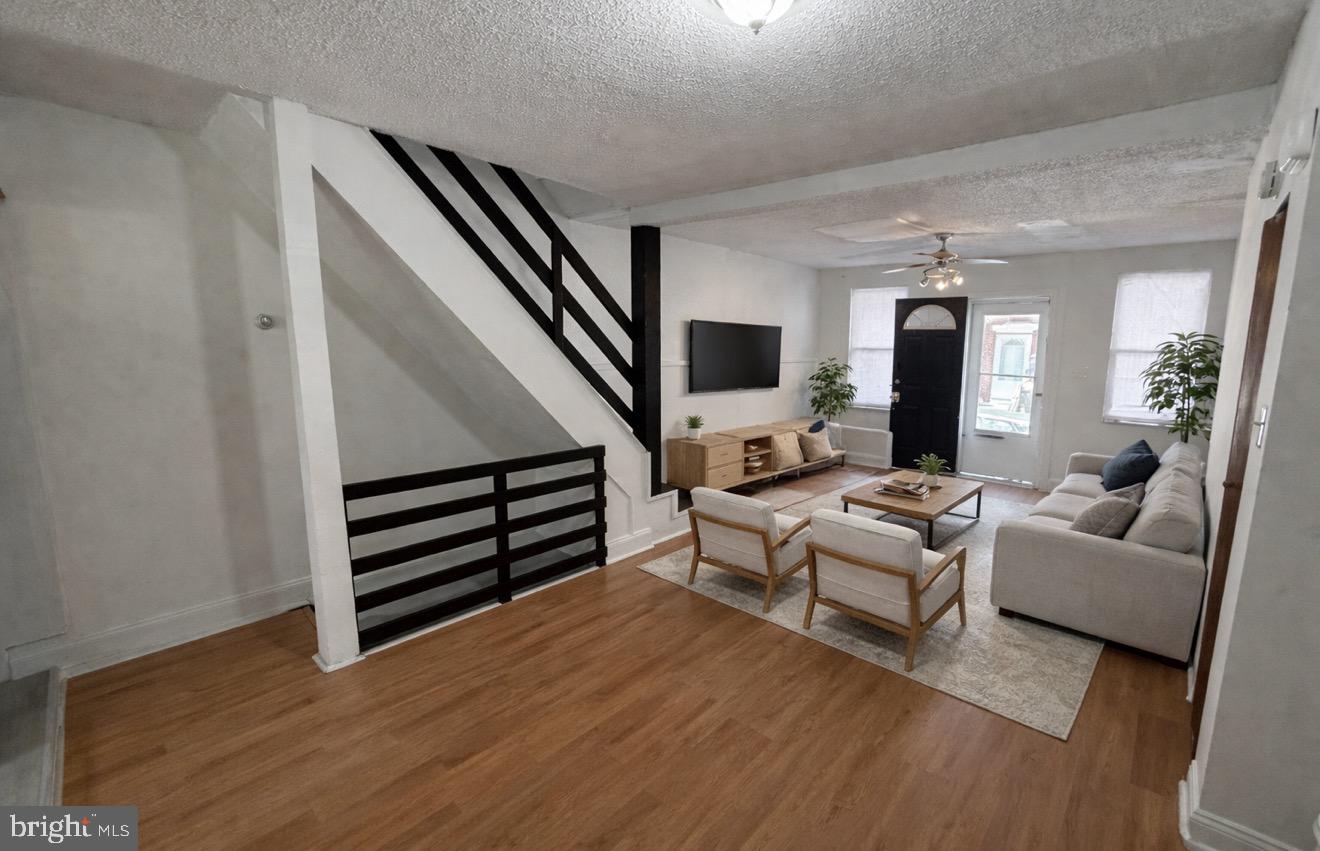 a living room with furniture and a wooden floor