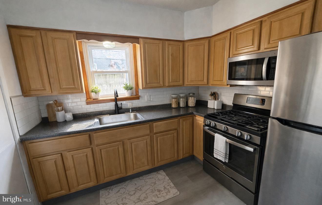 1327 South Newkirk Street Philadelphia, PA 19146 - Photo 3 of 7 a kitchen with stainless steel appliances granite countertop a stove a sink and a microwave