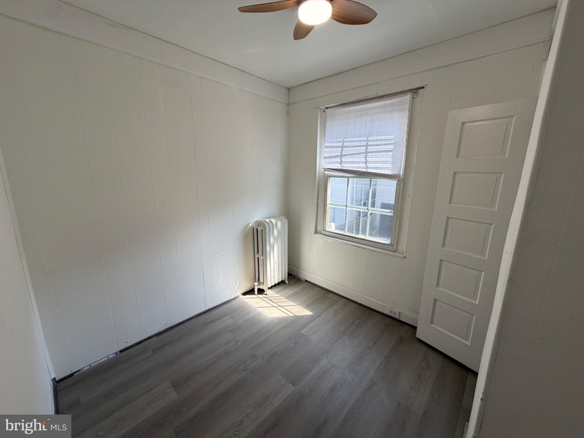 1327 South Newkirk Street Philadelphia, PA 19146 - Photo 5 of 7 an empty room with wooden floor and windows