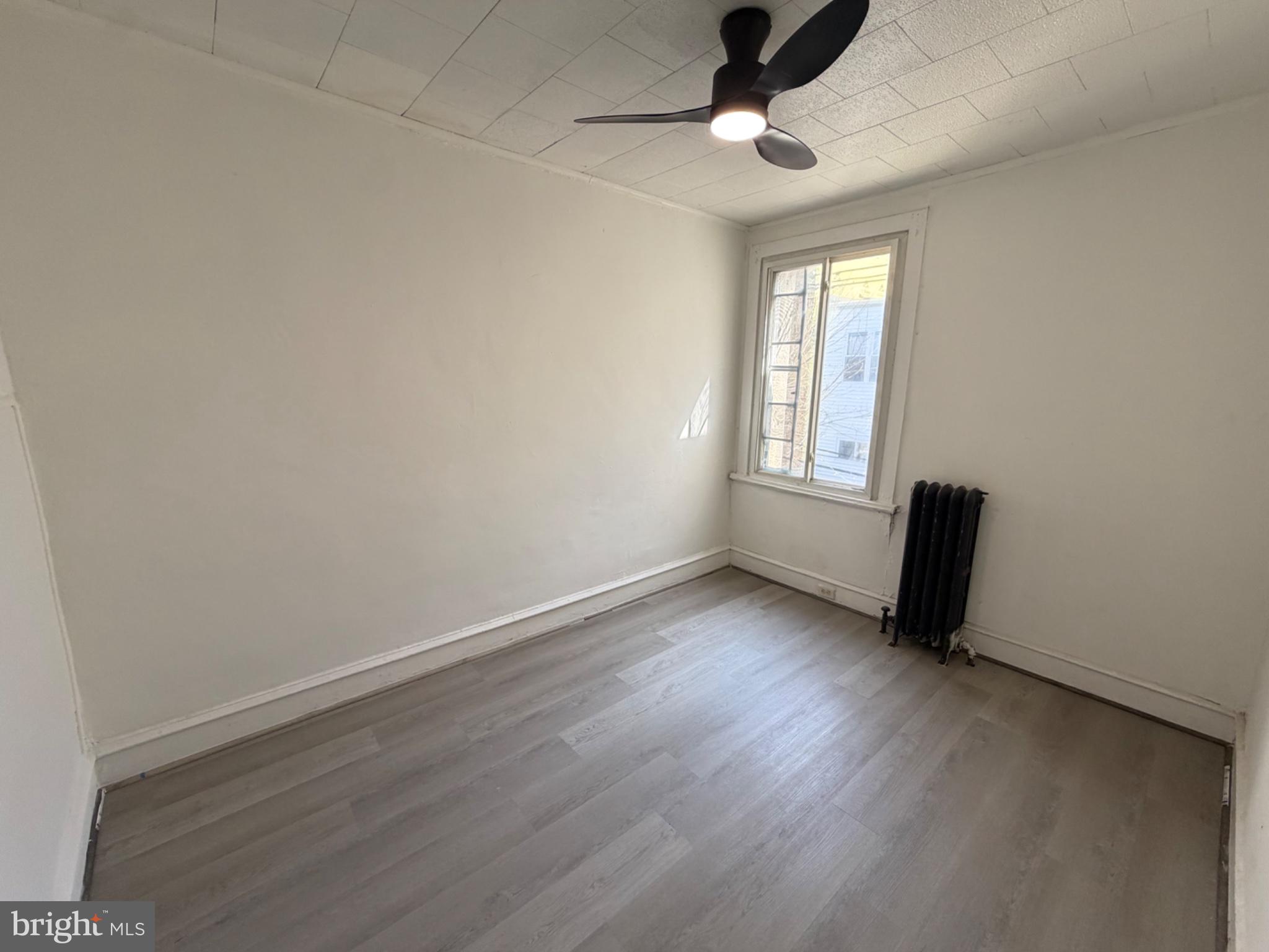 1327 South Newkirk Street Philadelphia, PA 19146 - Photo 6 of 7 an empty room with wooden floor and windows