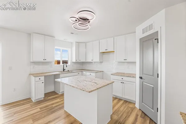 a large white kitchen with cabinets