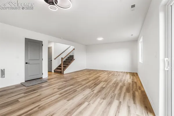 a view of a hallway with wooden floor and staircase