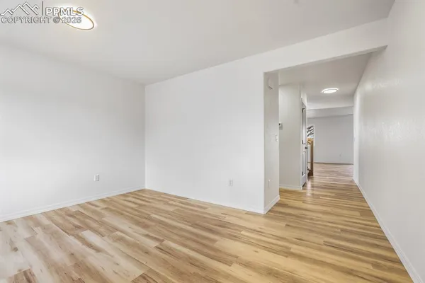 a view of empty room with wooden floor