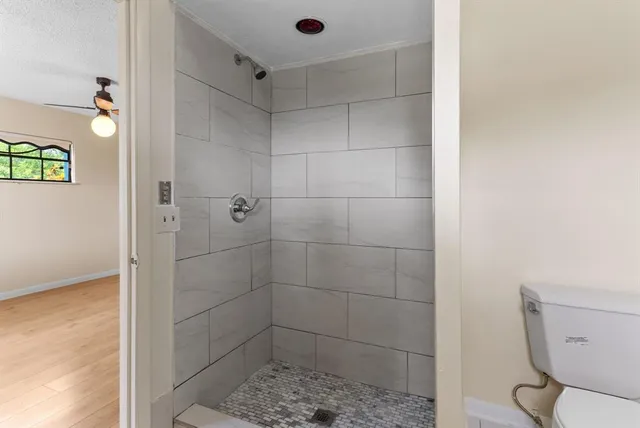 a bathroom with a toilet and a shower