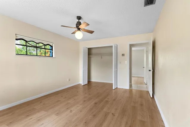 a view of room with hardwood floor and ceiling fan