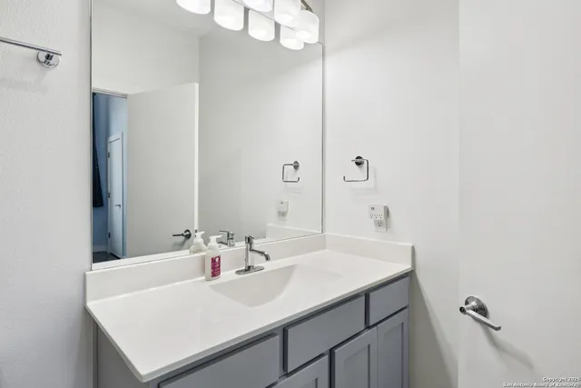a bathroom with a sink a mirror and a vanity