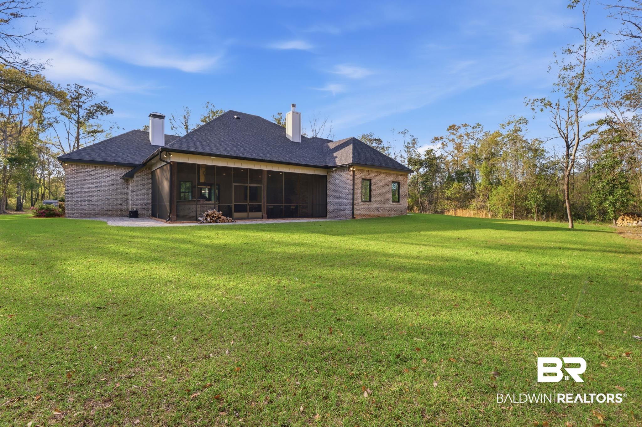 9501 Ben Hamilton Road Theodore, AL 36582 - Photo 67 of 69 Rear view of house featuring a lawn, a chimney, brick siding, a sunroom, and a shingled roof