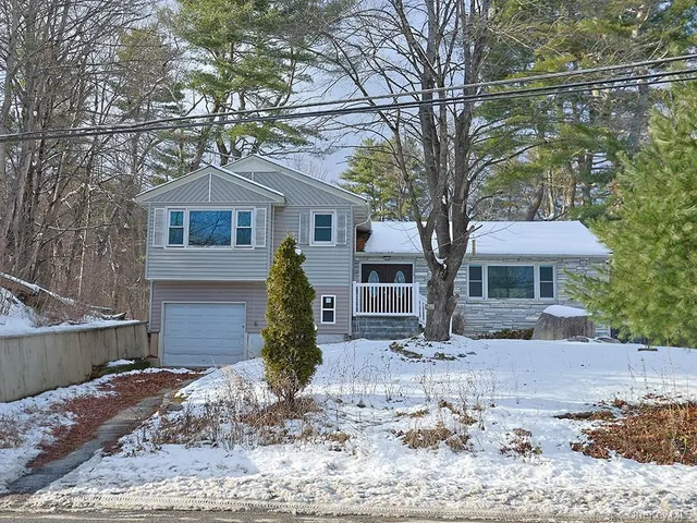 a view of a hallway with a livingroom and furniture