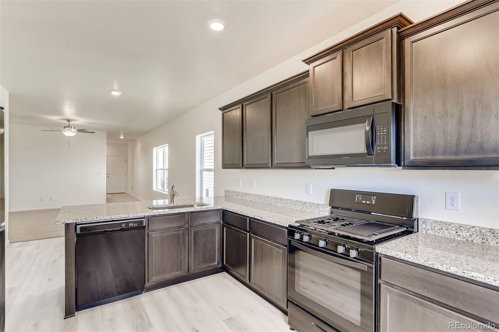 47517 Clover Avenue Bennett, CO 80102 - Photo 11 of 22 a kitchen with a sink stove and microwave