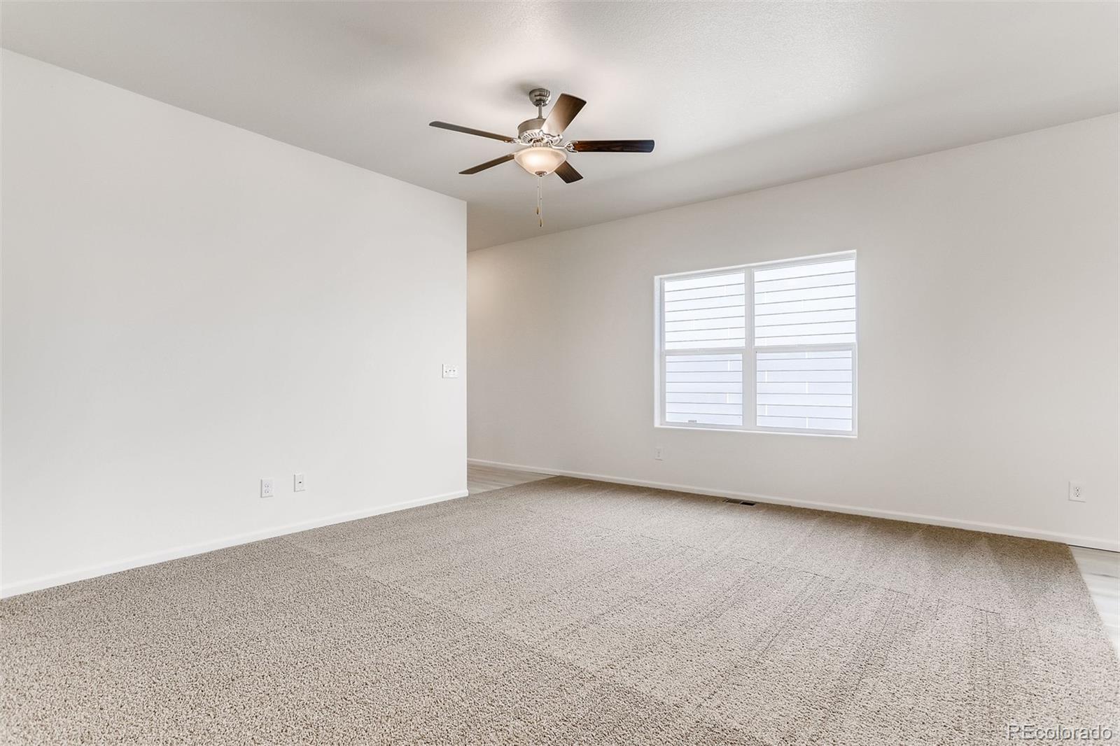 47517 Clover Avenue Bennett, CO 80102 - Photo 5 of 22 an empty room with windows and ceiling fan