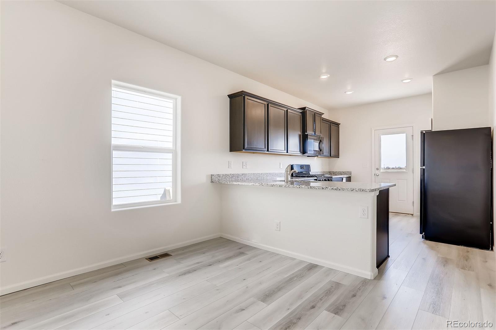 47517 Clover Avenue Bennett, CO 80102 - Photo 7 of 22 a view of kitchen with granite countertop cabinets and refrigerator