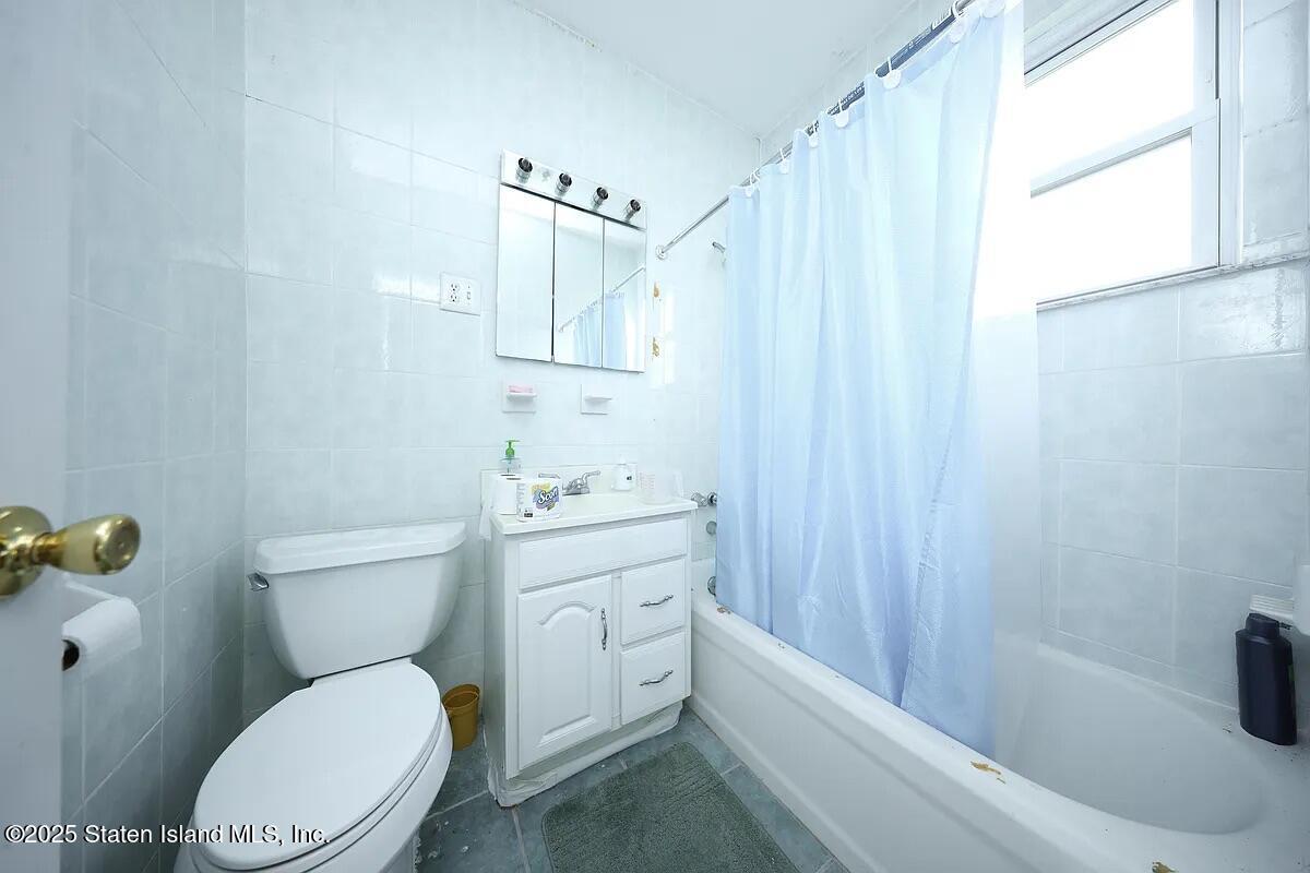 1905 Clove Road Staten Island, NY 10304 - Photo 11 of 29 a bathroom with a toilet a sink and bathtub