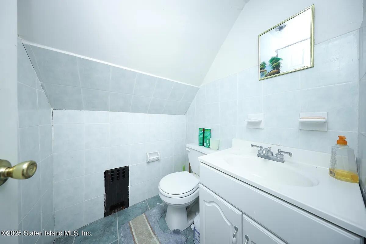 1905 Clove Road Staten Island, NY 10304 - Photo 13 of 29 a bathroom with a sink a toilet and a mirror