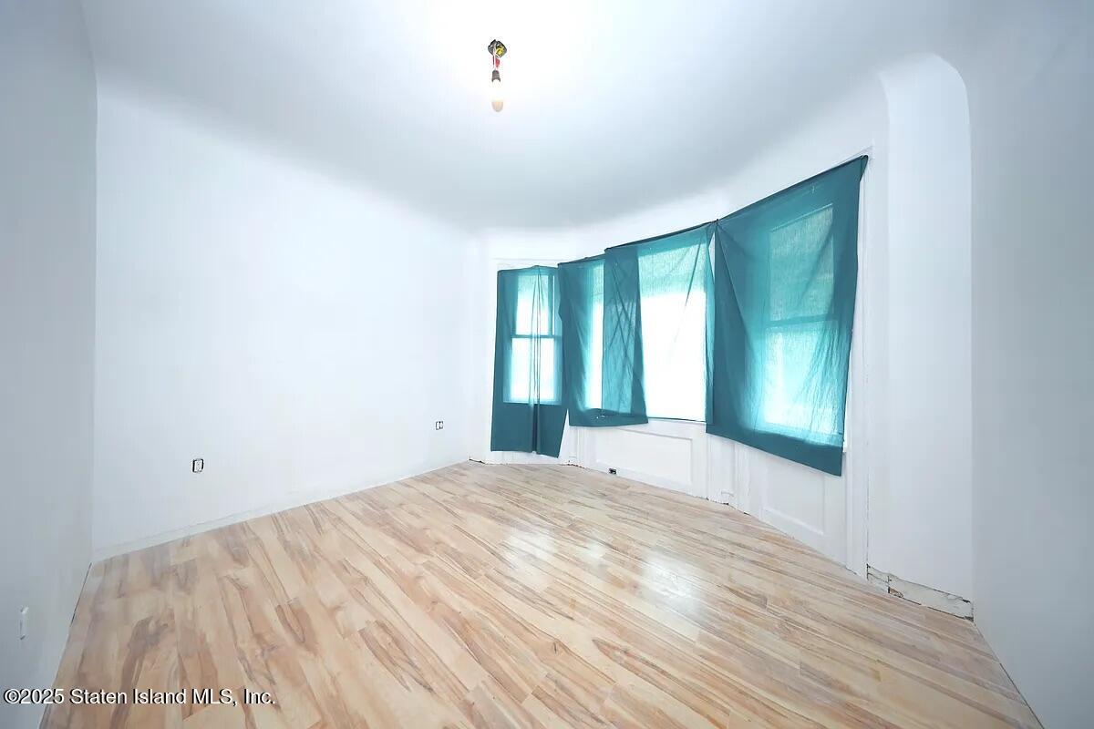 1905 Clove Road Staten Island, NY 10304 - Photo 15 of 29 a view of an empty room with wooden floor and a window