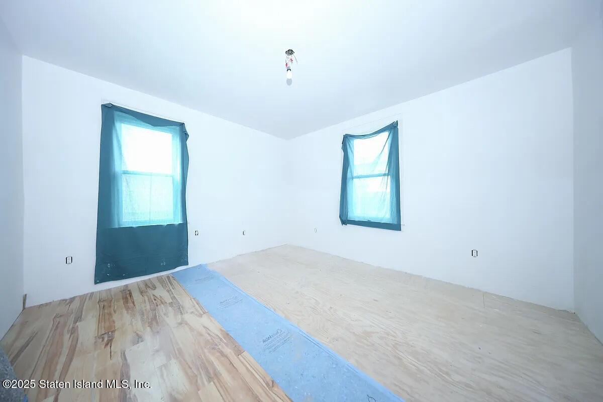 1905 Clove Road Staten Island, NY 10304 - Photo 19 of 29 an empty room with wooden floor and windows