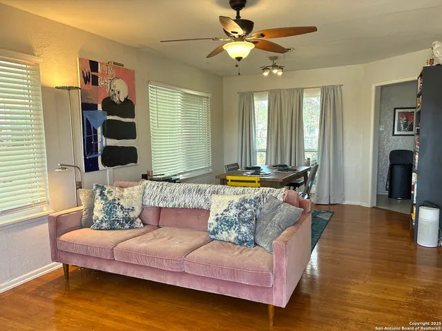 a living room with dining table and a flat screen tv