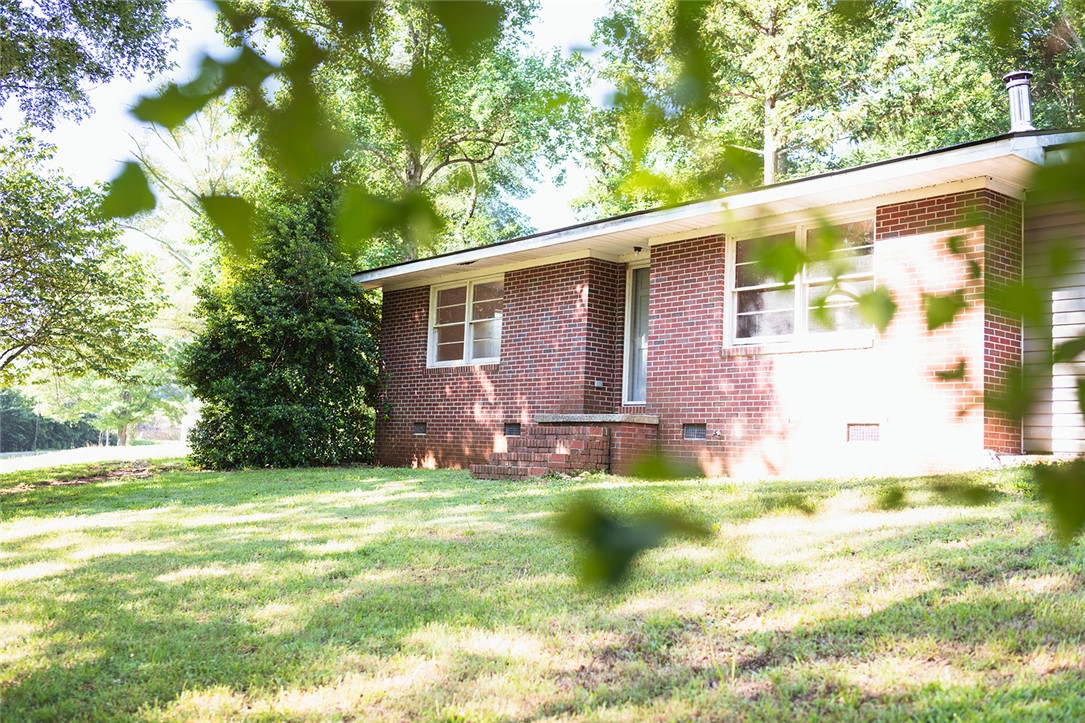 209 Cleveland Pike Road Westminster, SC 29693 - Photo 1 of 30 A well-maintained brick exterior residence nestled amidst mature trees.