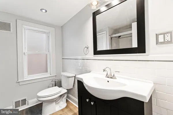 a bathroom with a sink a toilet and mirror