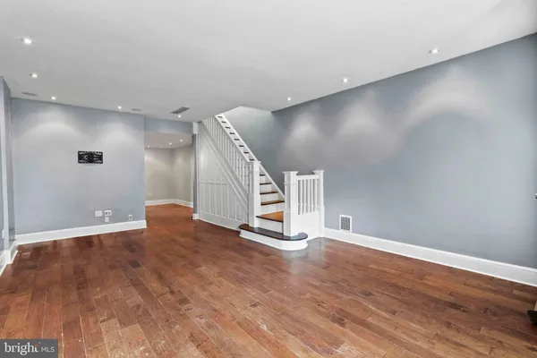a view of an empty room with wooden floor