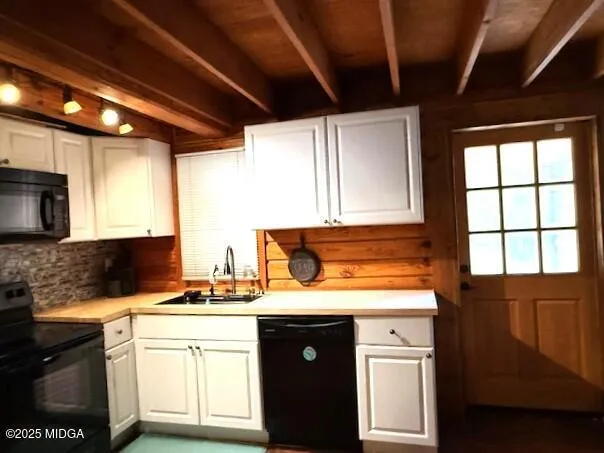 a kitchen with stainless steel appliances granite countertop a stove a sink and white cabinets