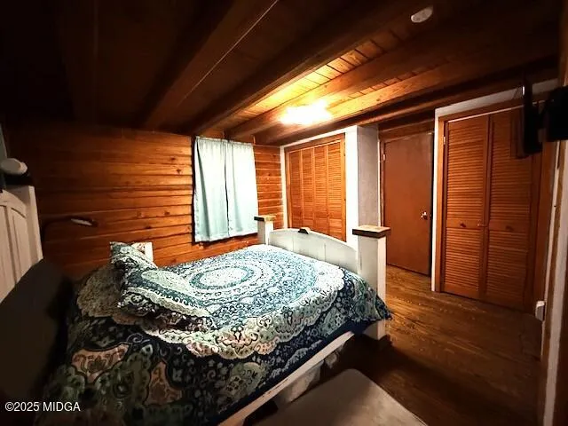 a bedroom with a bed and a dresser next to a window
