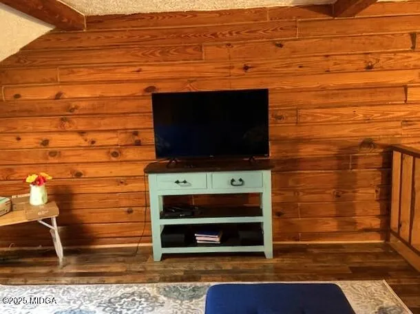 a living room with stainless steel appliances wooden floor and a rug