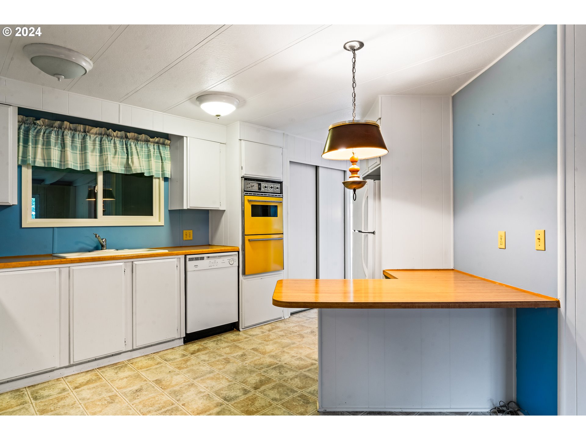 1600 Rhododendron Drive, Unit 406 Florence, OR 97439 - Photo 13 of 42 a kitchen with kitchen island sink and refrigerator