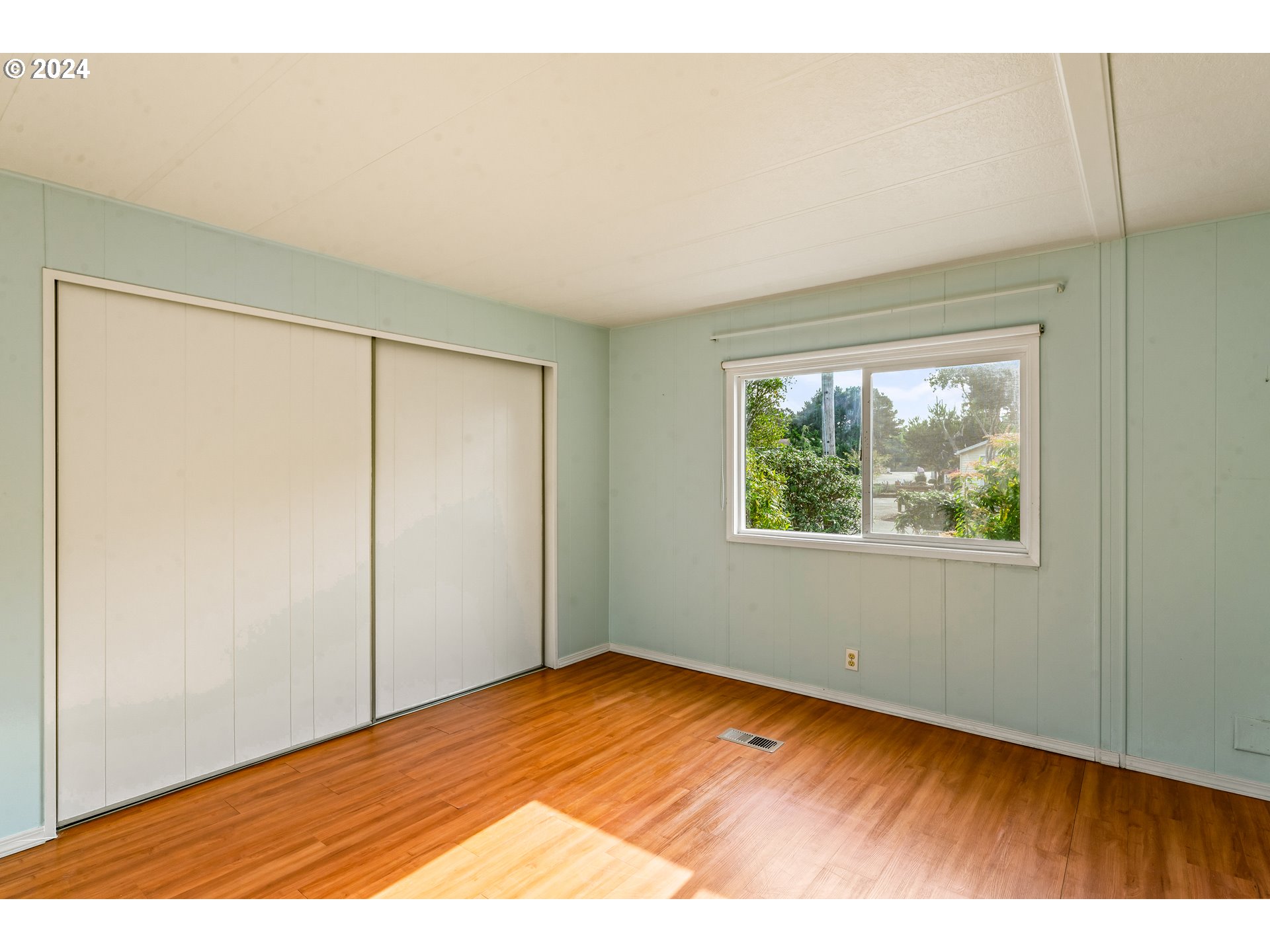 1600 Rhododendron Drive, Unit 406 Florence, OR 97439 - Photo 18 of 42 a view of an empty room with wooden floor and a window