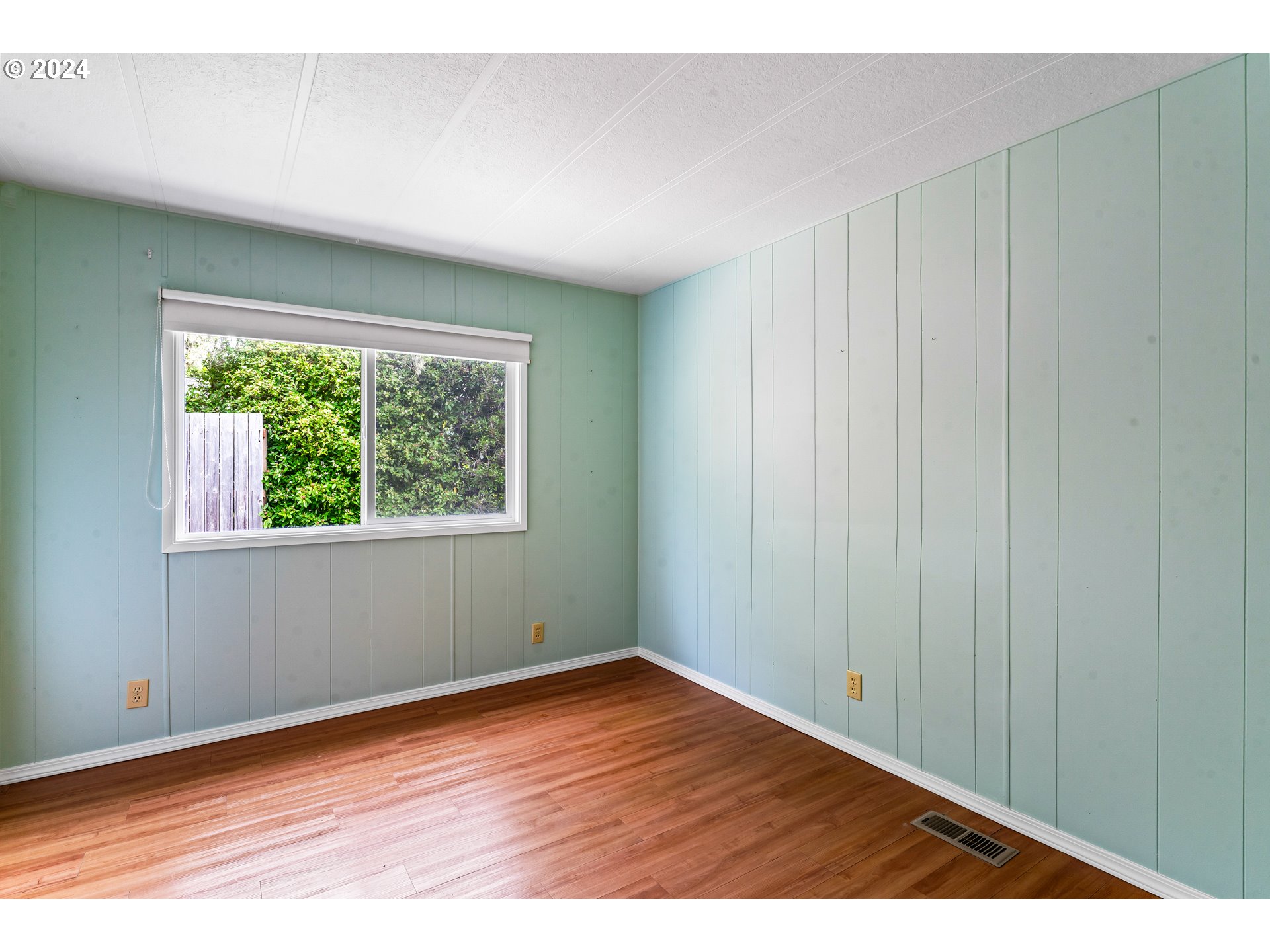 1600 Rhododendron Drive, Unit 406 Florence, OR 97439 - Photo 30 of 42 a view of an empty room with wooden floor and a window