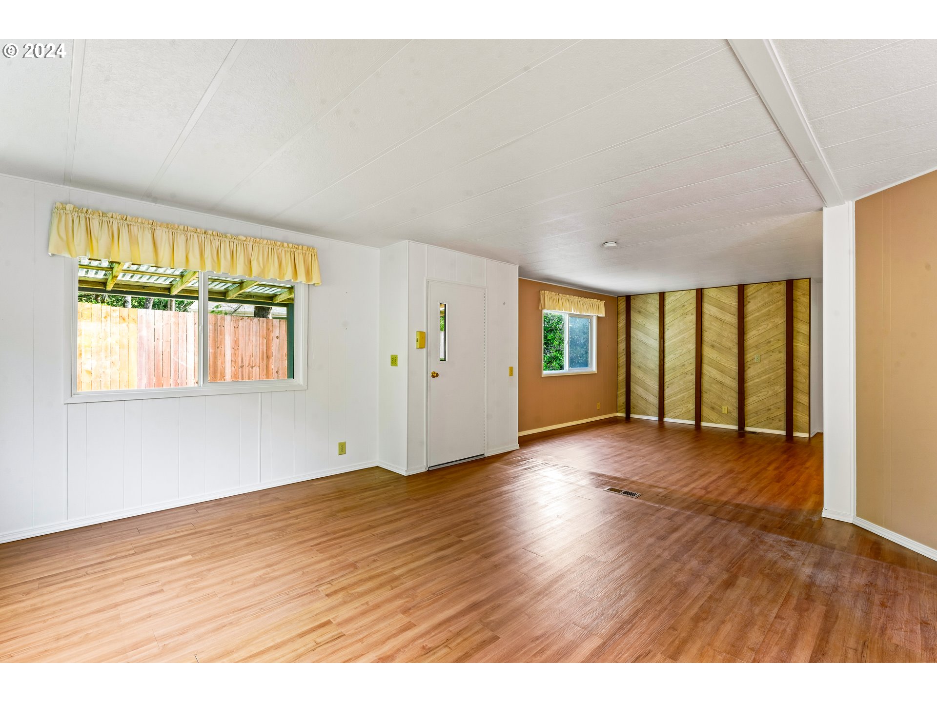 1600 Rhododendron Drive, Unit 406 Florence, OR 97439 - Photo 9 of 42 a view of an empty room with wooden floor and a window