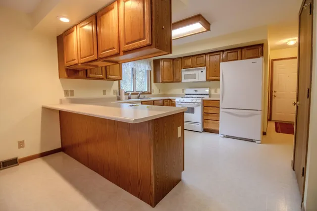 a kitchen with stainless steel appliances granite countertop a refrigerator a stove a sink and a microwave