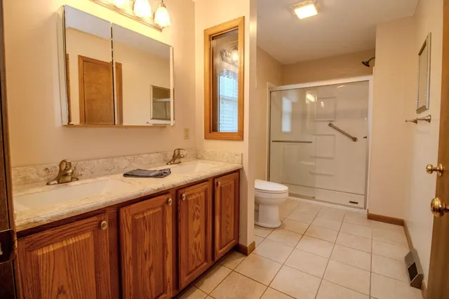 a bathroom with a granite countertop sink toilet and shower
