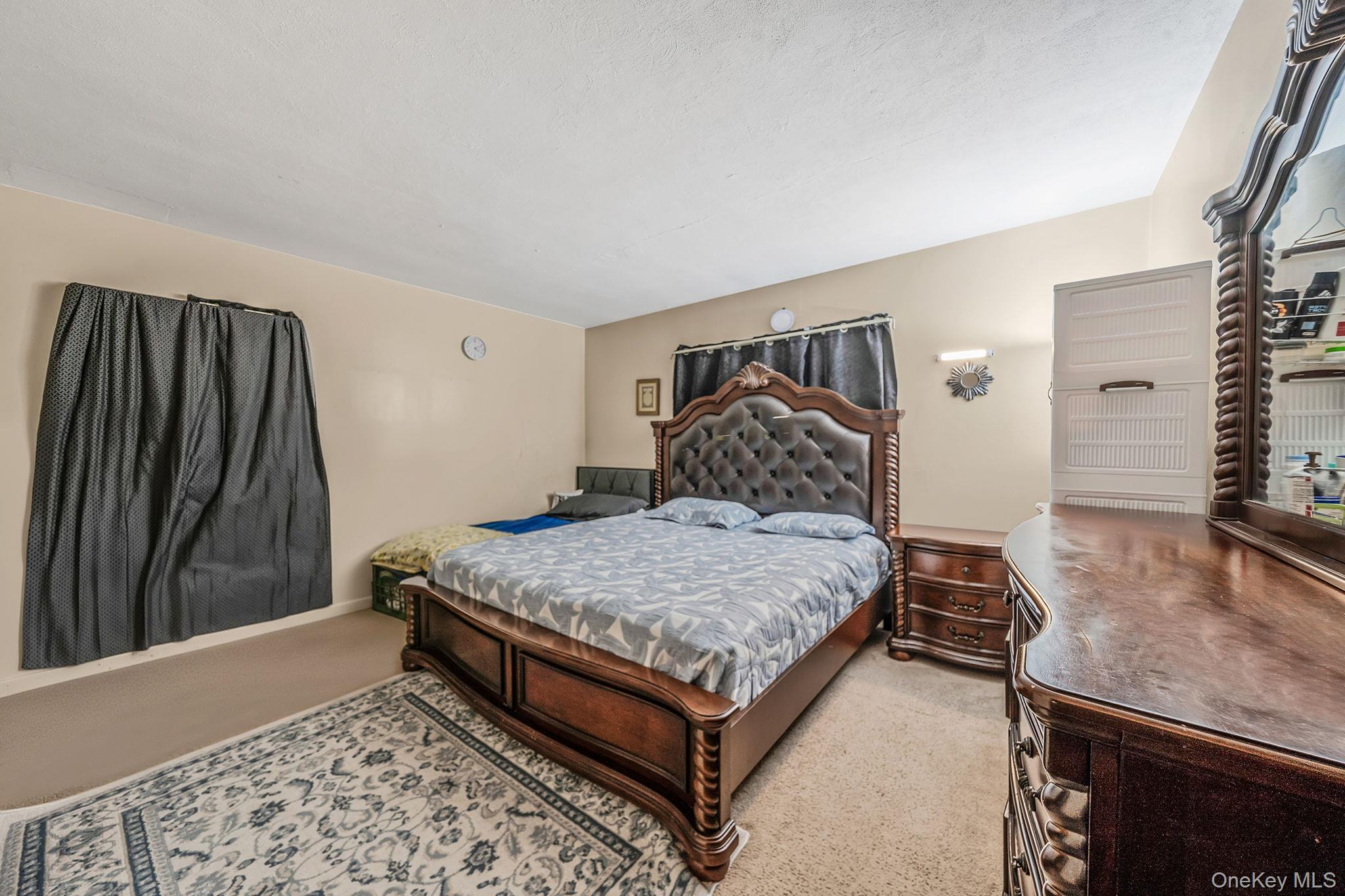 98 Miriam Street Valley Stream, NY 11581 - Photo 11 of 16 a bedroom with a bed and a dresser with wooden floor