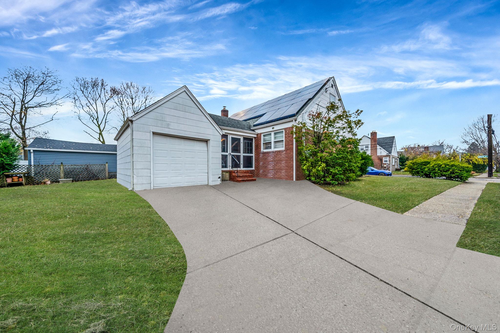 98 Miriam Street Valley Stream, NY 11581 - Photo 2 of 16 a front view of a house with a yard and garage