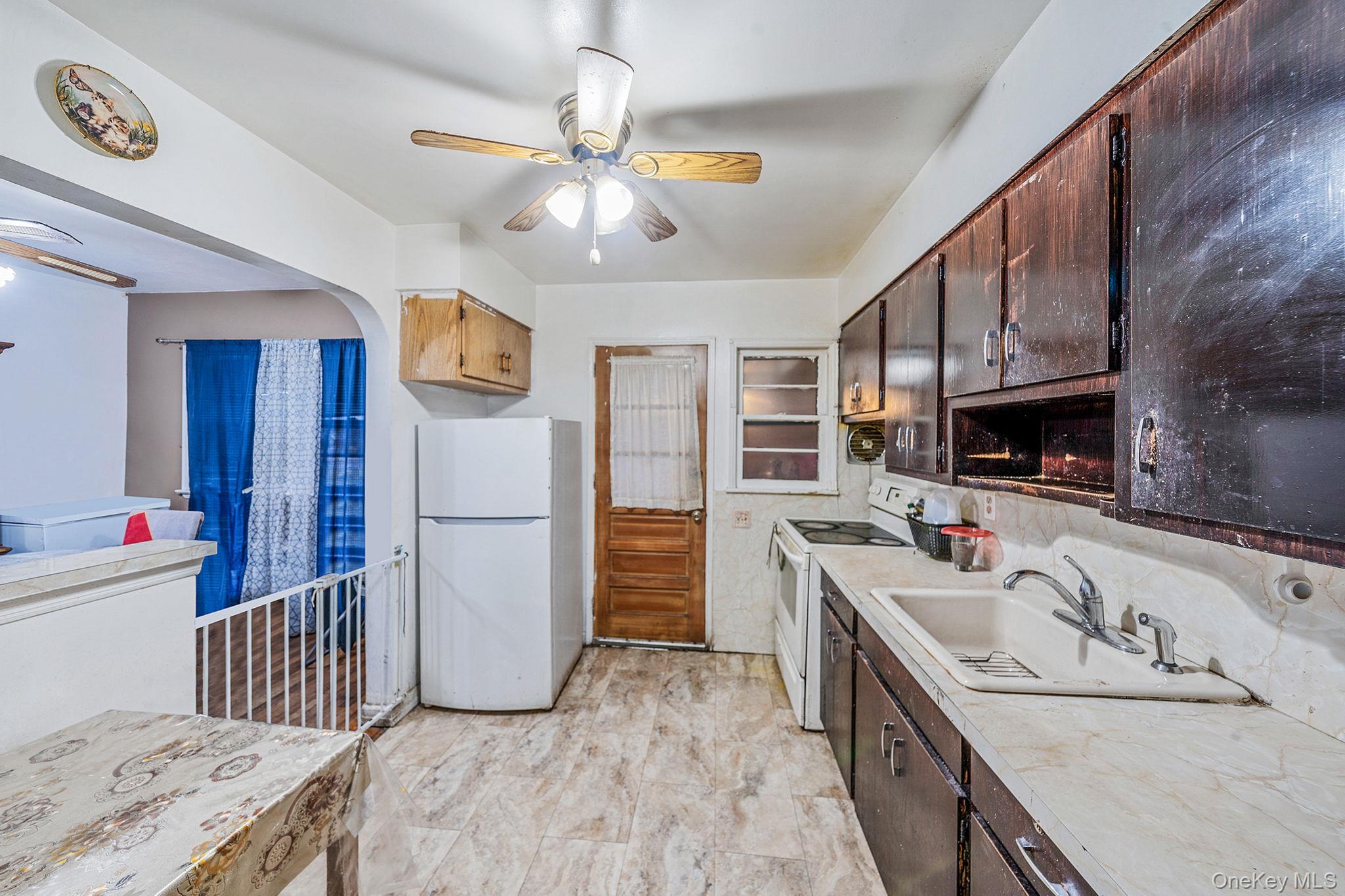 98 Miriam Street Valley Stream, NY 11581 - Photo 4 of 16 a kitchen with stainless steel appliances granite countertop a sink stove and refrigerator
