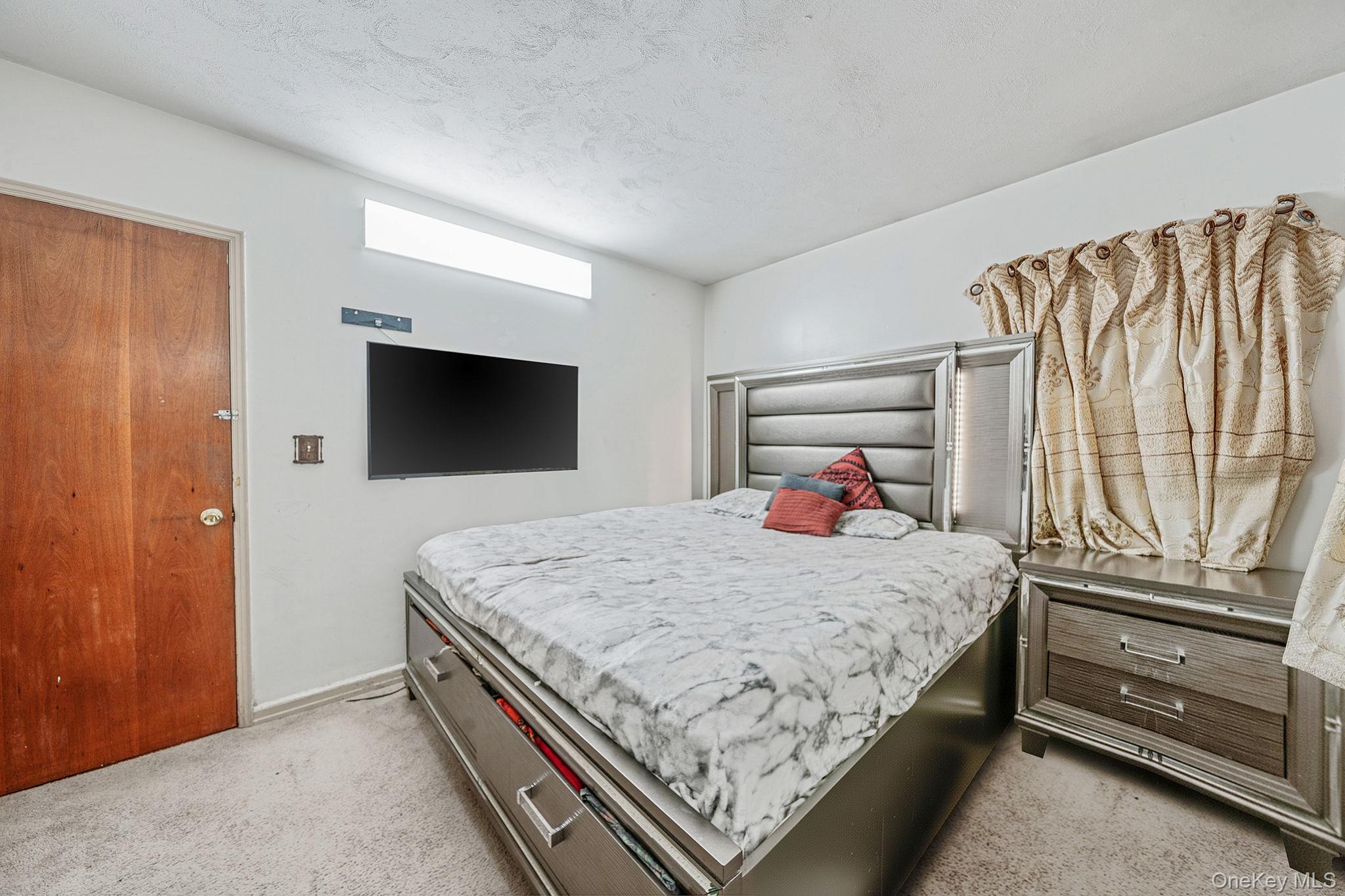 98 Miriam Street Valley Stream, NY 11581 - Photo 7 of 16 a bedroom with a bed and a flat screen tv