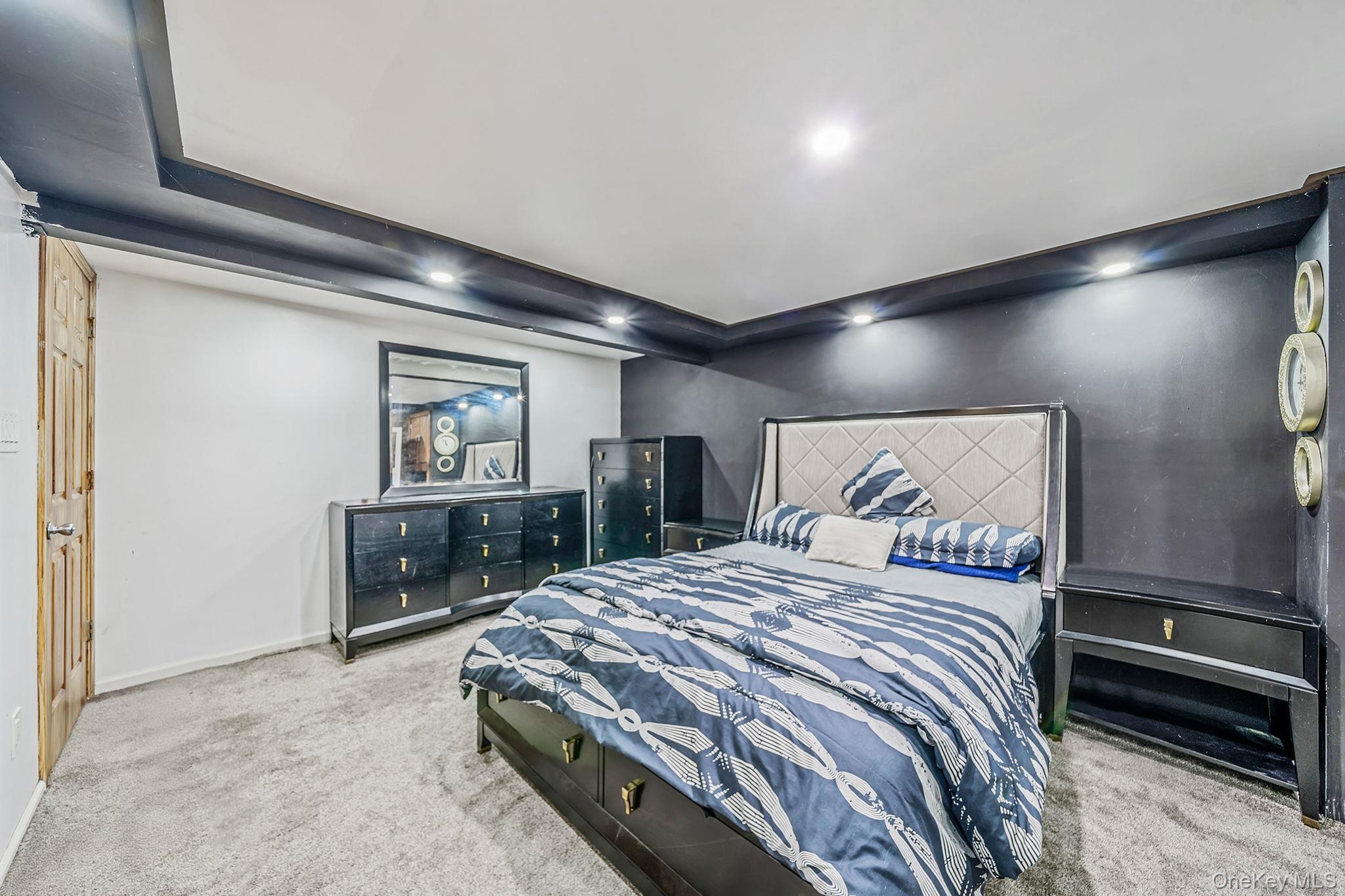 98 Miriam Street Valley Stream, NY 11581 - Photo 10 of 16 a bedroom with a large bed and a chandelier