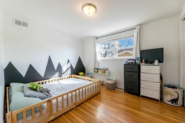 a bedroom with furniture and a wooden floor