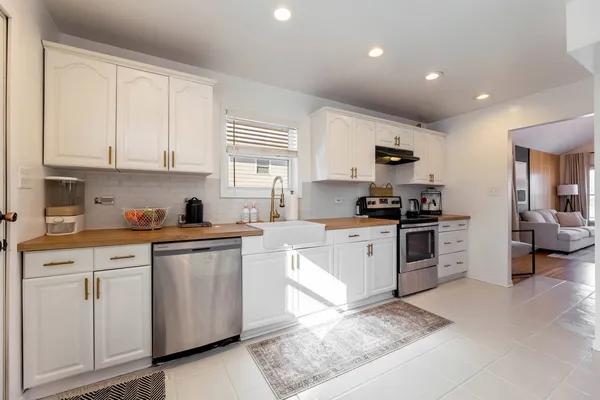 a kitchen with granite countertop white cabinets and white appliances