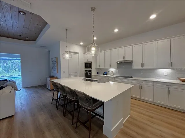 a kitchen with a dining table chairs sink and cabinets