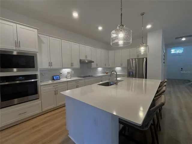 a kitchen with kitchen island a stove sink and cabinets