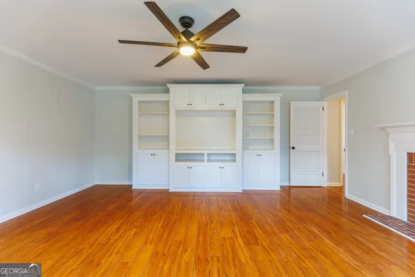 a view of a big room with wooden floor and a ceiling fan