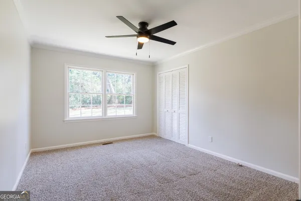 a view of a livingroom with a ceiling fan and window